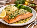 Soczysty łosoś z airfryer, podany z puree ziemniaczanym, brokułami i cytryną. Danie posypane świeżą natką pietruszki.