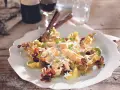 Omas Spargelsalat mit cremigem Dressing, Eiern und Kräutern, serviert auf einem weißen Teller mit Salatblättern.