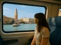 Donna guarda fuori dal finestrino del treno, ammirando il panorama di Venezia. Un modo suggestivo per capire come arrivare a Venezia.