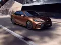 Brązowa Toyota Camry Hybrid w ruchu. Sprawdź aktualną toyota camry cena i wybierz swój wymarzony model.