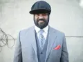 Gregory Porter w eleganckim garniturze i czapce, gotowy na koncert.