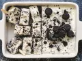 Oreo glass recept: krämig glass med krossade Oreos och hela kakor, skuren i bitar med träpinnar. Perfekt sommardessert!