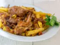 Piatto di ziti alla genovese con ragù di carne e cipolle caramellate, guarnito con prezzemolo fresco.