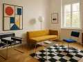 Minimalistyczny salon w stylu bauhaus: żółta kanapa, czarno-biała szachownica na dywanie, krzesła z chromowanej stali i abstrakcyjny obraz.