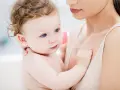 Ein Baby mit blauen Augen und zerzaustem Haar wird von seiner Mutter gehalten. Es ist fast 46 Wochen alt und durchläuft einen Entwicklungsschub.