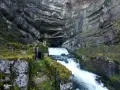 La source de la Loue, un spectacle naturel impressionnant. L'itinéraire mène à travers ce paysage rocheux où l'eau jaillit d'une grotte.