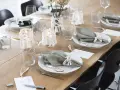 Vacker dukning med gröna servetter, ljus och blommor. Perfekt fest dekoration inspiration för ett stilrent hem.