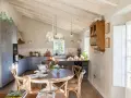 Cocina rústica y acogedora. Ideas para decorar casa vieja de pueblo con poco dinero. Techos de madera, muebles grises y mesa redonda.
