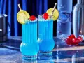 Dwa orzeźwiające drinki Blue Lagoon z cytryną i wiśnią, gotowe do podania.