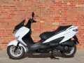 Biały skuter Suzuki Burgman 125, idealny do miasta, z niskim spalaniem.