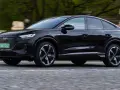Czarny Audi Q4 e-tron w ruchu. Sprawdź, jaki jest jego zasięg na jednym ładowaniu.