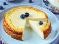 Ein köstlicher low carb Kuchen mit Blaubeeren, der auf einem Teller serviert wird. Ein Stück ist bereits herausgeschnitten.