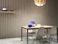 Paredes acanaladas que disimulan imperfecciones, mesa de comedor con sillas modernas y un estante con decoración.