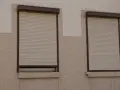 Prawda o rzekomym zakazie montażu rolet zewnętrznych w blokach pod opieką architekta. Dwa okna z roletami zewnętrznymi na elewacji.
