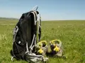 Sac à dos et chaussures de randonnée ornées de jonquilles, prêts pour une randonnée sur l'Aubrac.