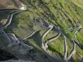Strada tortuosa che sale verso il passo più alto d'Europa, con tornanti stretti e panorami mozzafiato.
