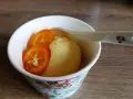 Erfrischendes Kalamansi-Sorbet in einer blumig dekorierten Schale, garniert mit zwei Scheiben der exotischen Frucht.