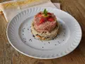 Due torri di riso, una rosa con fragole e menta, l'altra bianca con verdure e semi neri. Un piatto che ricorda la crema di riso.