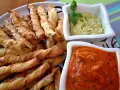 Chrupiące paluszki grissini z ziołami, idealne do podania z kremowym guacamole i pikantnym sosem pomidorowym.