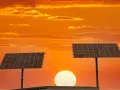 Dwa panele fotowoltaiczne na tle zachodzącego słońca. To pokazuje, co daje fotowoltaika – czystą energię ze słońca.