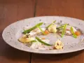 Vacker tallrik med piggvar recept: vit fisk, gröna bönor, orange rom och en krämig sås med nötter.