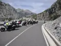 Grupa motocyklistów zatrzymała się na malowniczej drodze w Albanii, podziwiając spektakularne widoki gór.