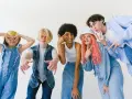 Ragazzi con un look anni '90, tutti vestiti di jeans, fanno pose divertenti.