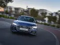 Niebieskie Audi A6 C8 w ruchu, z rozmazanym tłem budynków i drzew. Nawet przy potencjalnych usterkach, wygląda imponująco.