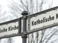 Straßenschilder weisen den Weg zur Evangelischen und Katholischen Kirche. Ein sichtbarer Unterschied katholisch evangelisch.