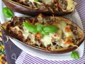 Melanzane ripiene al forno velocissime, dorate e filanti, guarnite con basilico fresco. Un piatto invitante e facile da preparare.