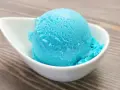 Ein Löffel leuchtend blaues Kaugummi Eis in einer weißen Schale. Perfekt für ein selbstgemachtes Kaugummi Eis Rezept.