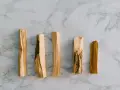 Cinco astillas de palo santo sobre mármol. ¿Por qué se apaga el palo santo? Quizás por la humedad o la mala ventilación.