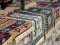 Kolorowe, tradycyjne kilimy z frędzlami. Idealne pamiątki, które warto kupić w Albanii.