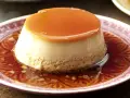 Delicioso flan de café con caramelo líquido, servido en un plato con un diseño intrincado.