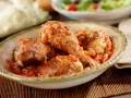 Pollo guisado en salsa de tomate y especias en un cuenco.