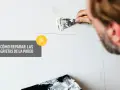 Hombre repara grietas en pared con aguaplast. Aprende por qué se agrieta el aguaplast y cómo solucionarlo.