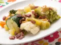 Un colorido panache de verduras con brócoli, coliflor, calabacín, zanahoria y patatas, salpicado de trocitos de jamón.