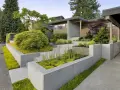 Modern entré inspiration utomhus med betongmurar, trappor och frodig grönska. En inbjudande och stilren design.