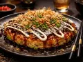 En läcker okonomiyaki med sås, majonnäs, sesamfrön och grön lök. Perfekt för ett okonomiyaki recept!