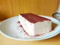 Un delizioso semifreddo al caffè, cosparso di cacao amaro, attende su un piatto bianco.
