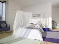 Acogedora habitación marinera con cama con dosel de tul, sillón azul y alfombras de colores.