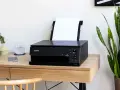 Schwarzer Canon Pixma Drucker mit WLAN verbinden. Ein Smartphone und ein Glas Wasser stehen daneben.