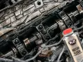 Zanieczyszczony silnik benzynowy i butelka K2 Motor Flush – najlepsza płukanka do silnika benzynowego, która przywróci mu czystość i moc.
