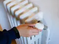 Ajustando el termostato de un radiador para optimizar la calefacción central en comunidades de vecinos.
