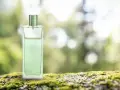 Elegancki perfum zielona herbata w szklanej butelce, stojący na mchu.
