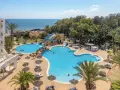 Hotel Marhaba Royal Salem kusi basenem z wodnymi zjeżdżalniami i palmami, w tle morze.