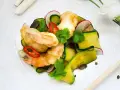 Chrupiące tempura do krewetek z cukinią, rzodkiewką i chili na białym talerzu.