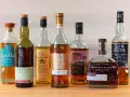 Eine Auswahl von sieben Flaschen, darunter Irish Whiskey und Scotch, die zu den top 10 besten Whisky zählen könnten.