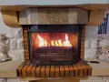Chimenea de leña con llamas vibrantes. El fuego ilumina el interior de la chimenea, creando un ambiente acogedor. Los pellets en la base de la chimenea se queman, alimentando las llamas.
