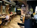 Wnętrze restauracji Urania Bistro z ludźmi przy stołach i barem.